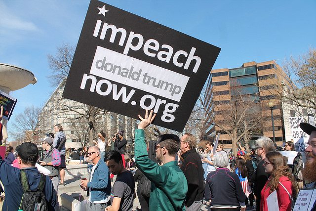 Crowd with person holding sign: "impeach donald trump now .org